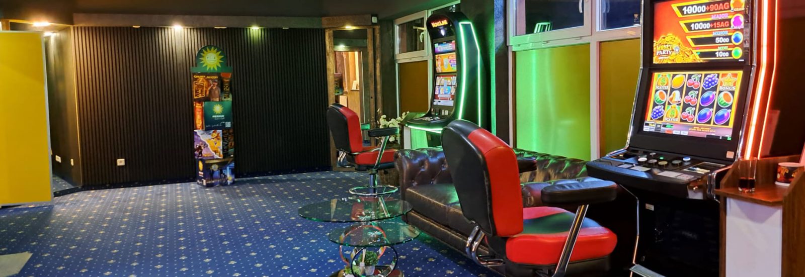 Sitzecke mit Ledersofa und Glastischen neben einem Spielgerät in der Spielhalle Wesel